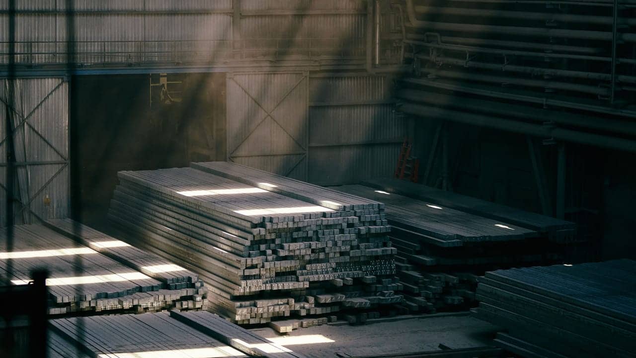 Industrijska hala sa složenim čeličnim gredama, u snopovima svjetla kroz prašinu