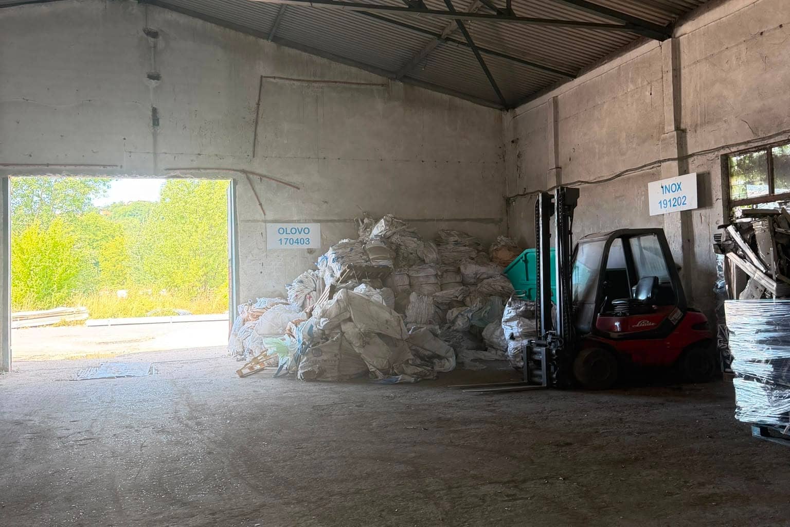 Bays in the hall marked OLOVO 170403 and INOX 191202, with a forklift and bulk bags